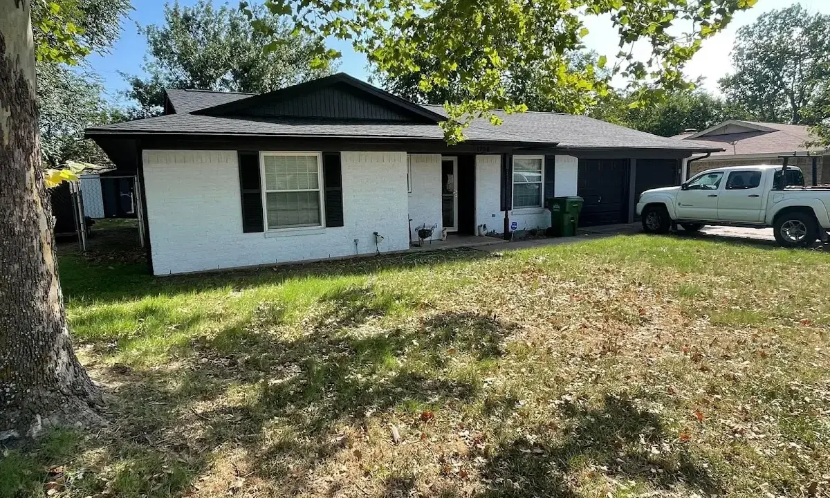 Professional roofing crew working on a residential roof in Adrian